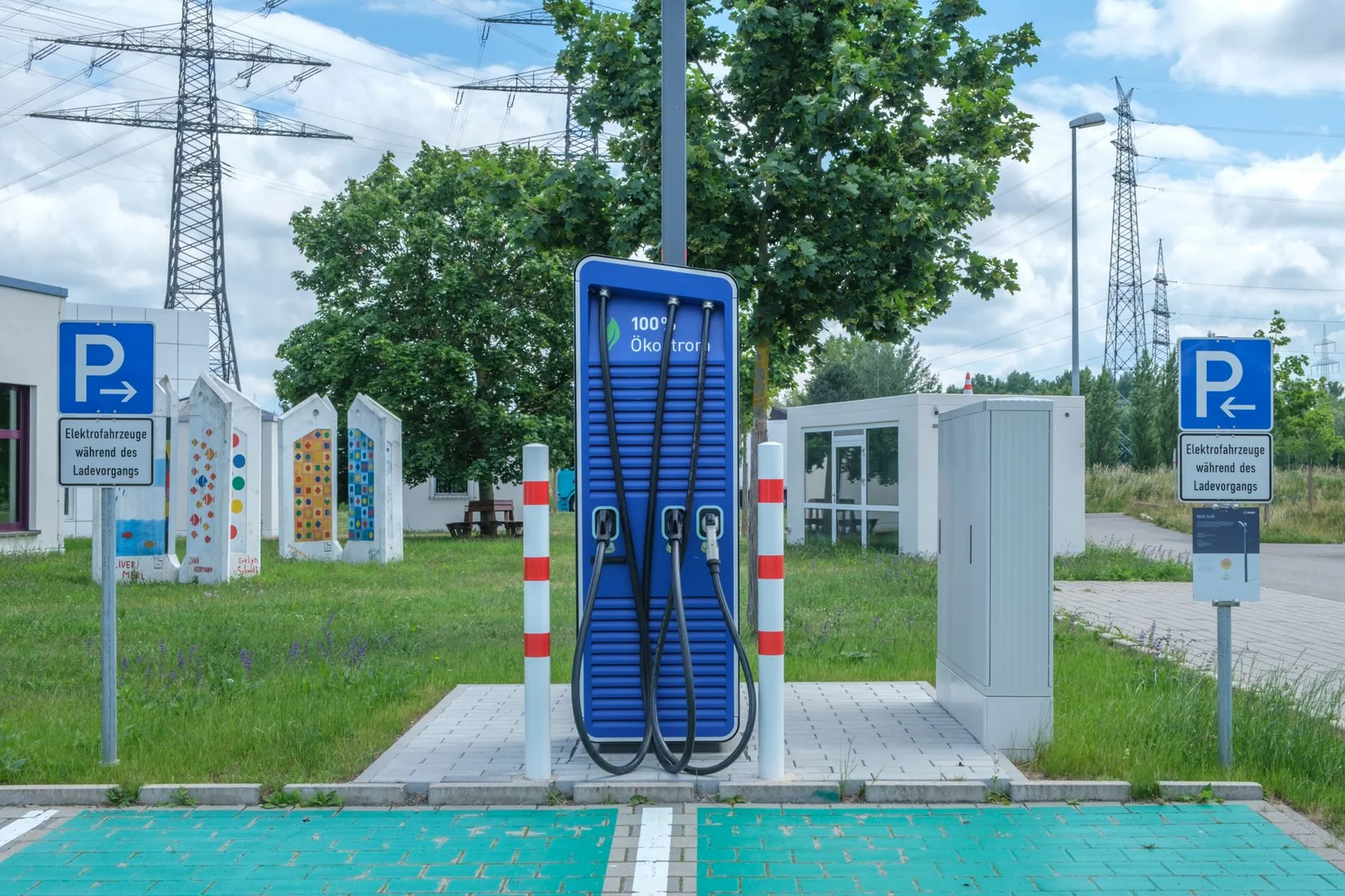 Voiture électrique blanche devant une borne de recharge en milieu urbain